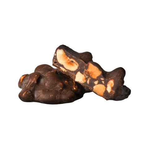 Closeup di due baciotti al cioccolato fondente. Uno intero e uno tagliato a metà per mostrare l'interno con nocciole Tonda Gentile Trilobata tostate